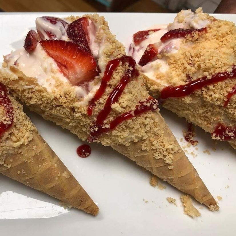 Strawberry ice cream cones with fresh strawberries and a strawberry drizzle