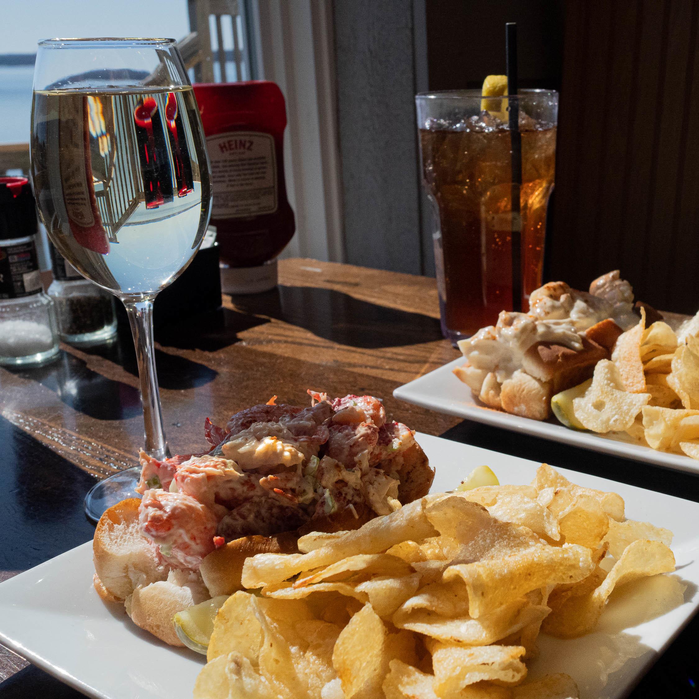 Sandwiches with chips and beverages overlooking the water