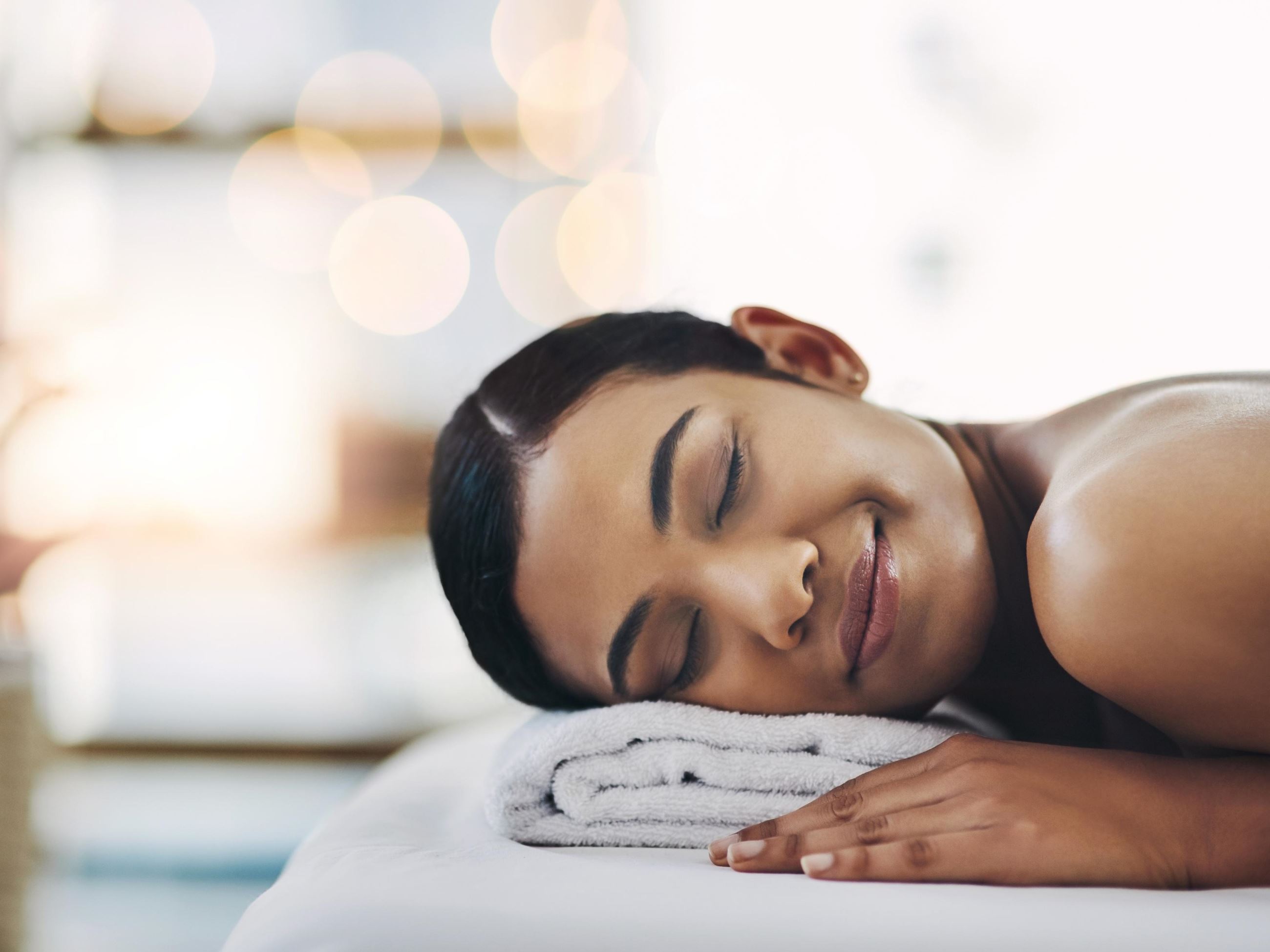 Woman laying on a towel relaxing at a spa