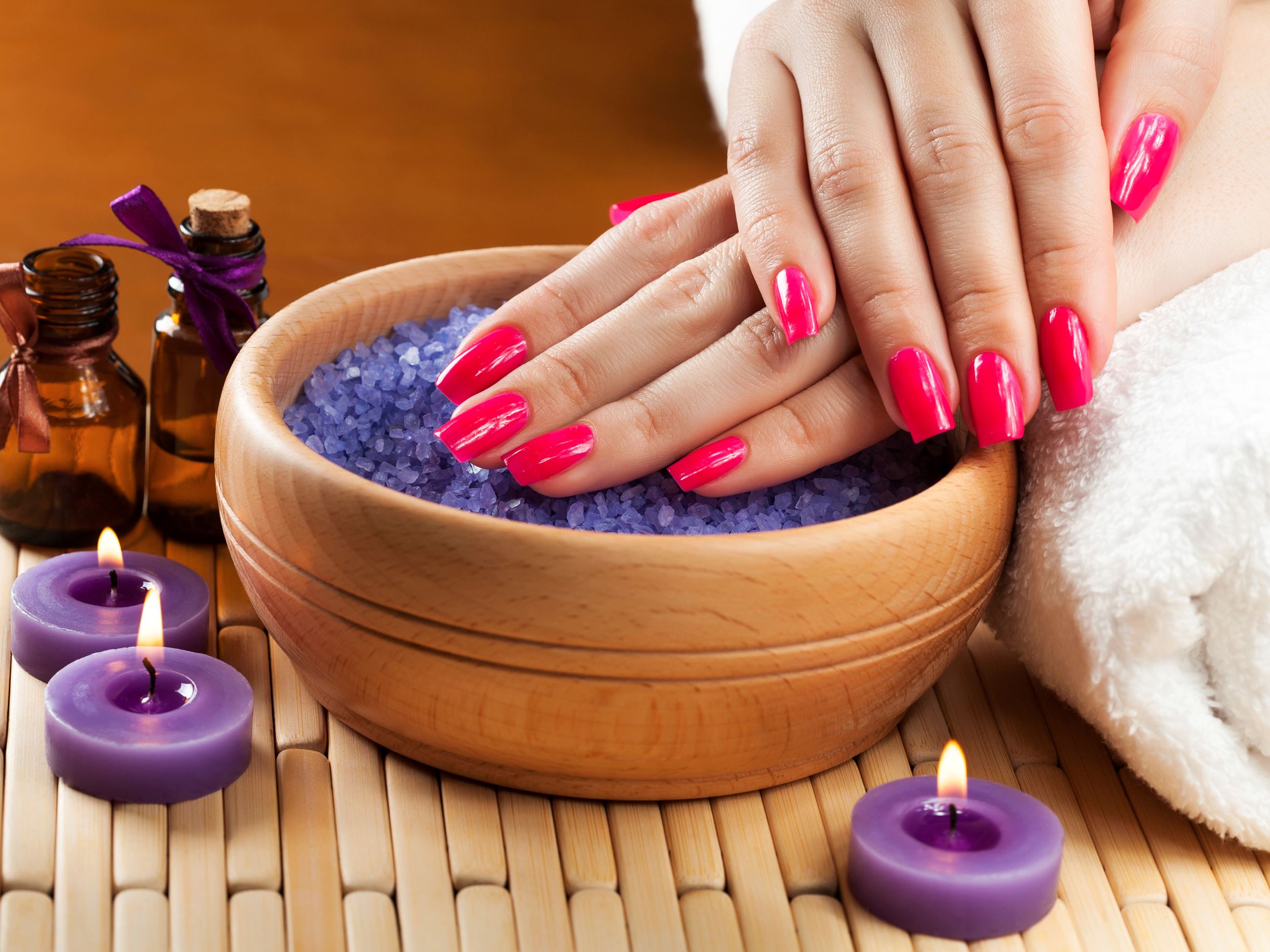 Woman's hands over a bowl with bright pink nails