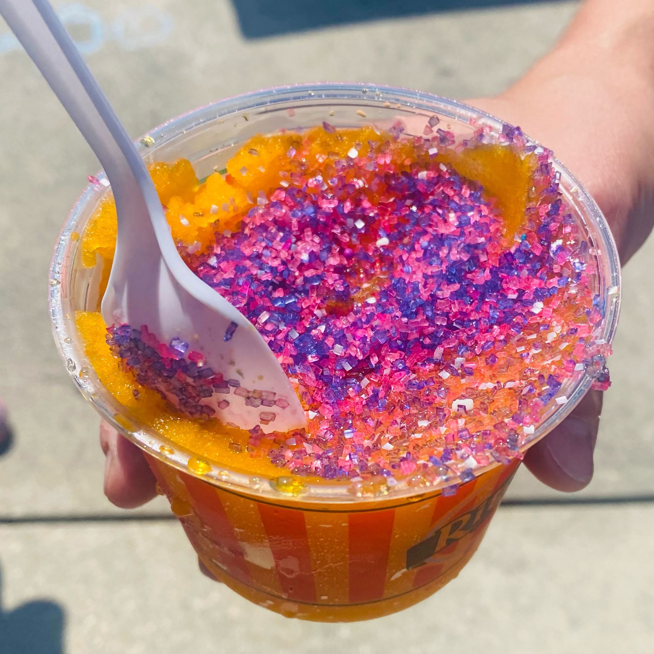 Orange Italian Ice with pink and purple sprinkles