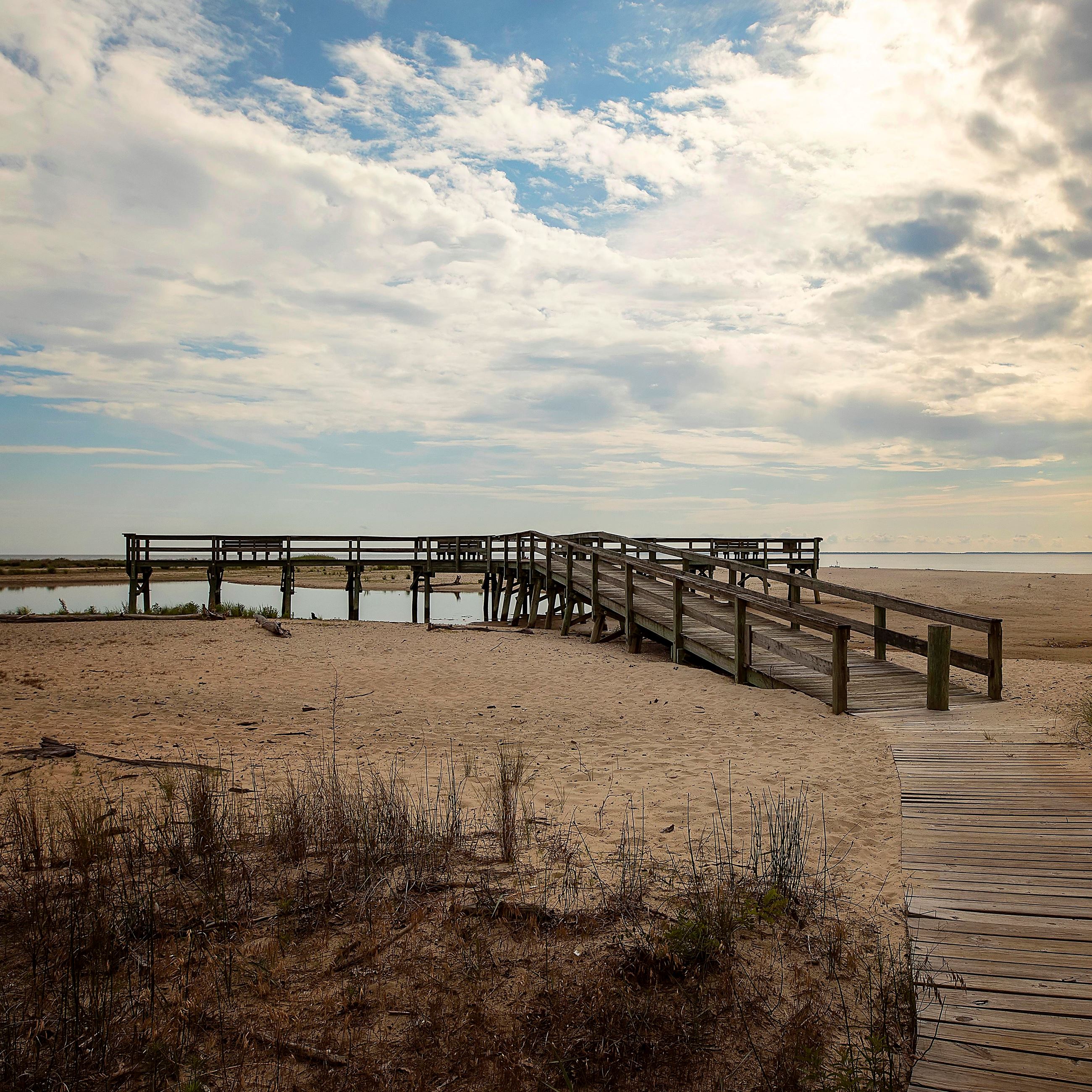 Flag Pond boardwalk to a dock that overlooks the water and a sunset