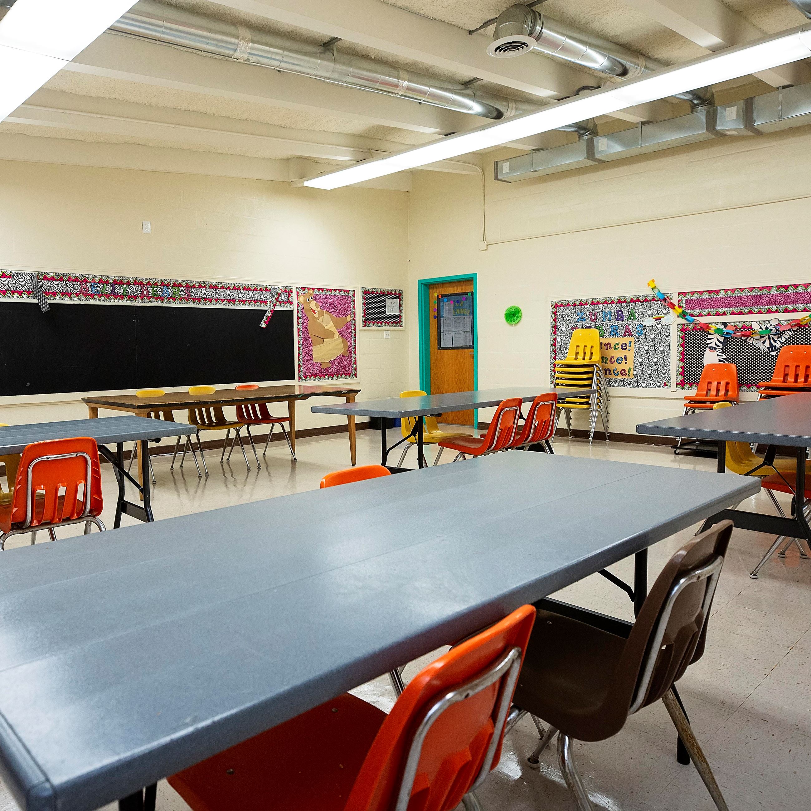 Meeting space with chairs, tables and a chalkboard