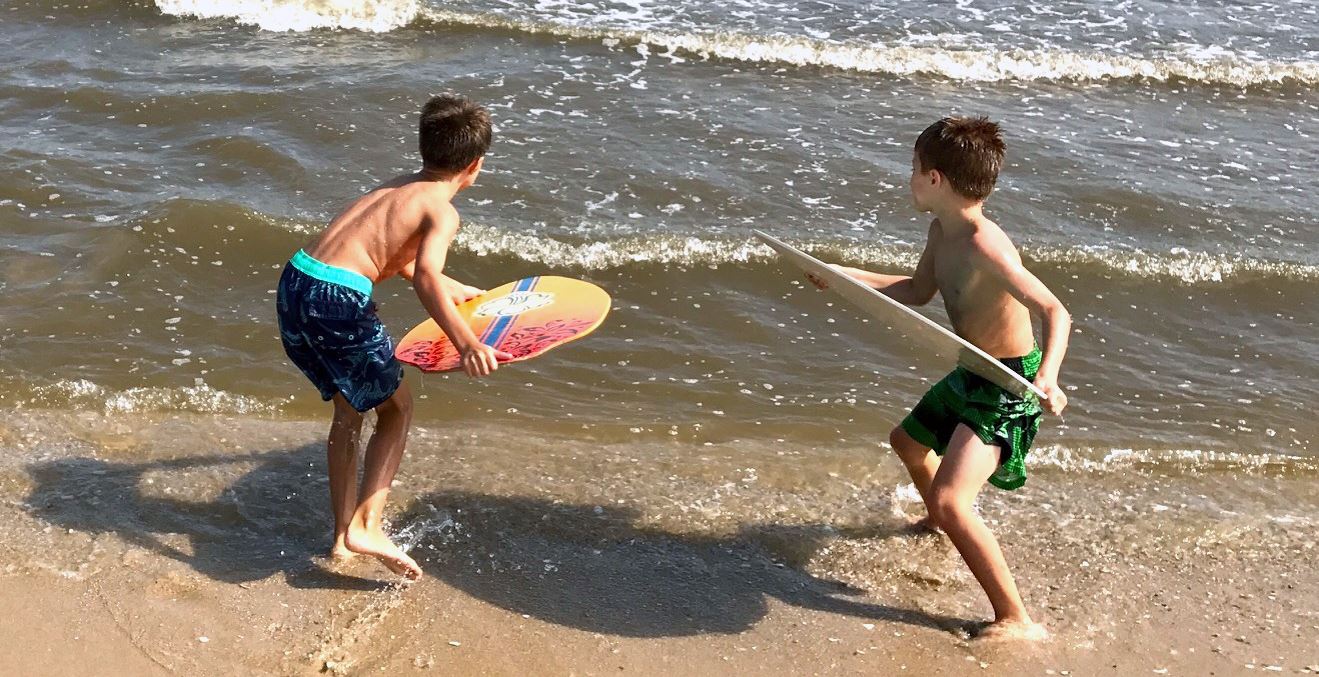 Children surfing on the beach