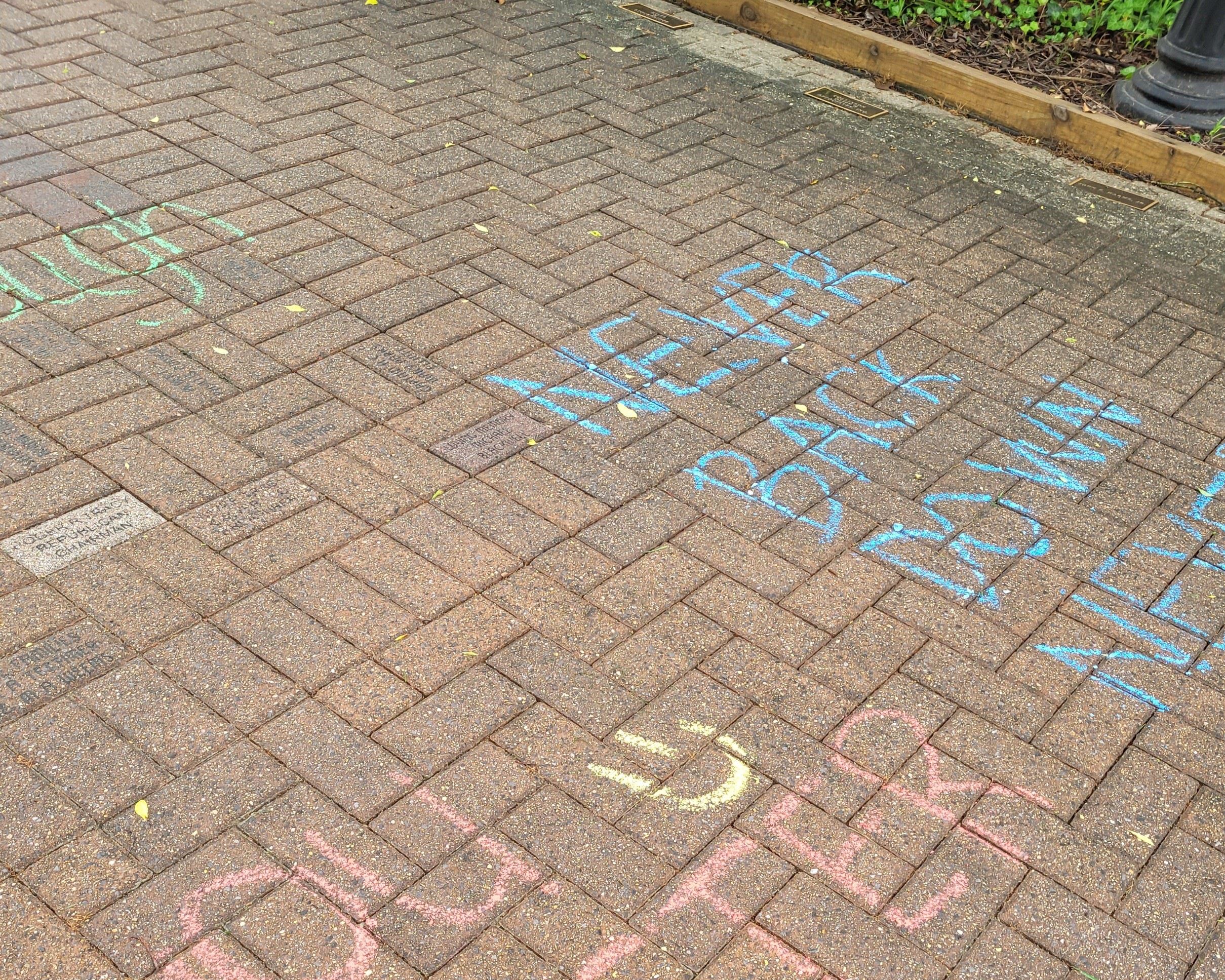 Chalk art on concrete stairs with text "Keep going! One step at a time."