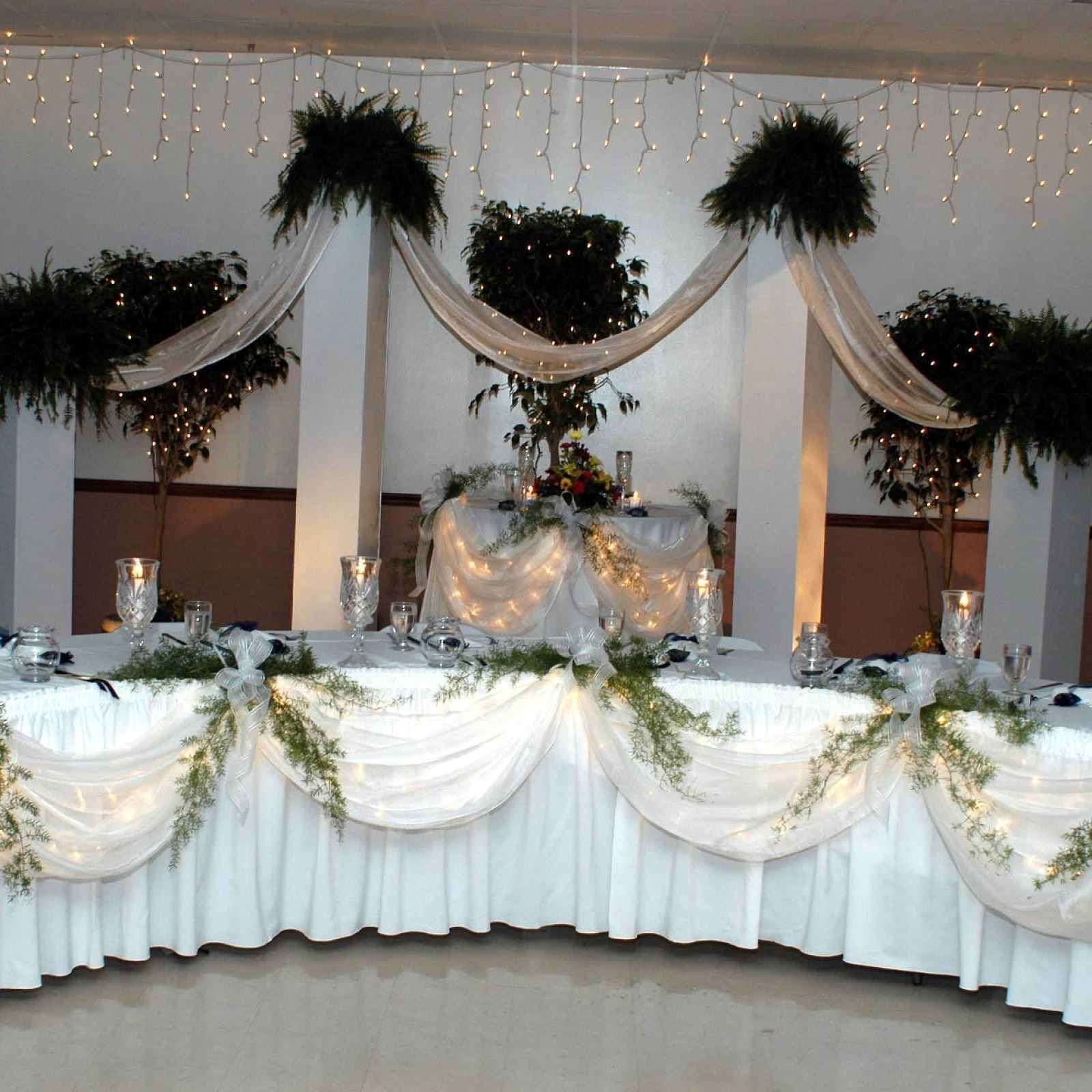 curved table with white tablecloth covered in glass candle holders