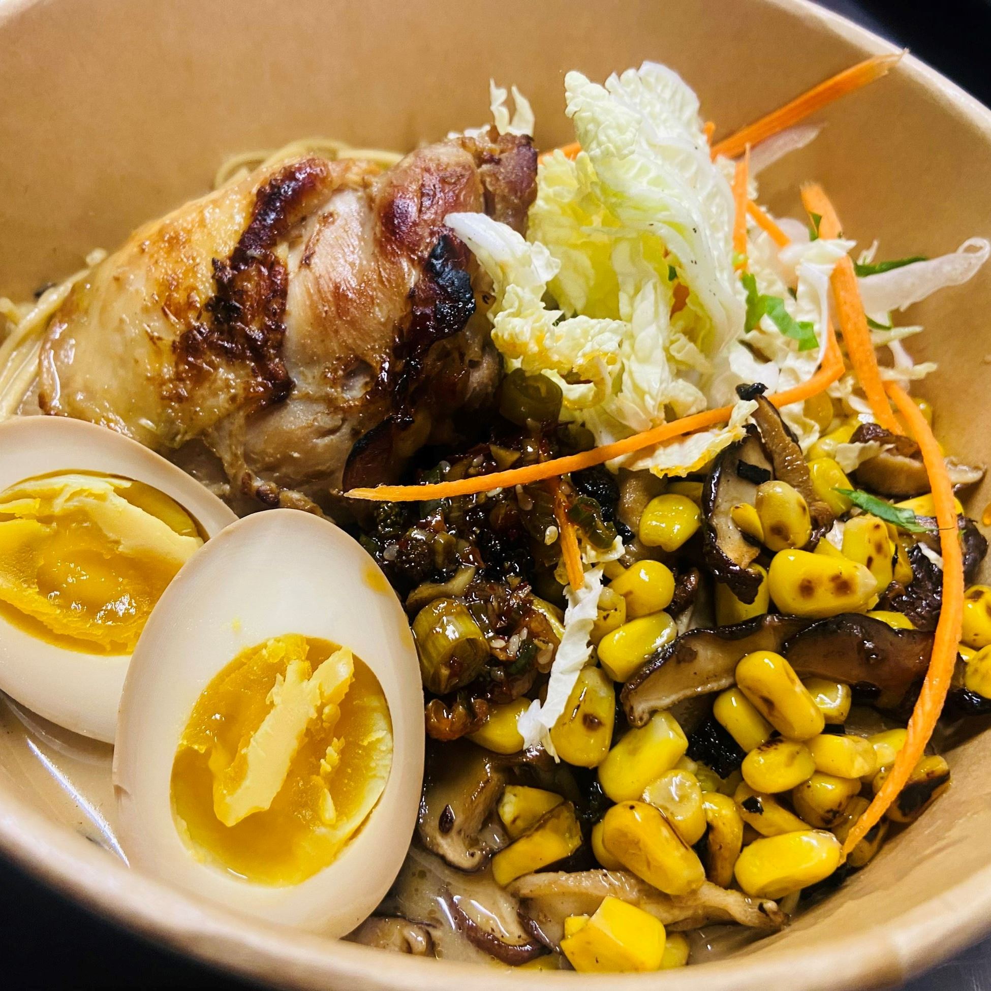 ramen with hardboiled egg, chicken and slaw in a bowl