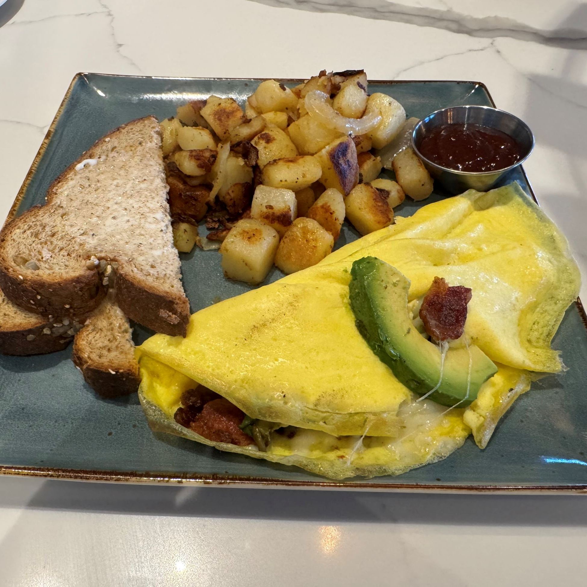 omelet, toast and potatoes on a square plate